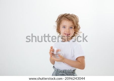 a little cute girl holds a glass  of water  isolated on a white background