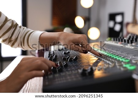 Woman working with professional mixing console in modern radio studio, closeup