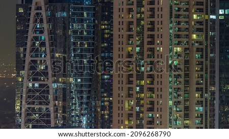 Night view of exterior apartment colorful buildings timelapse. High rise skyscraper with glowing lights in many windows