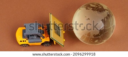 Technology and globalization concept. A toy loader brings a processor to the planet. Isolated on brown background.
