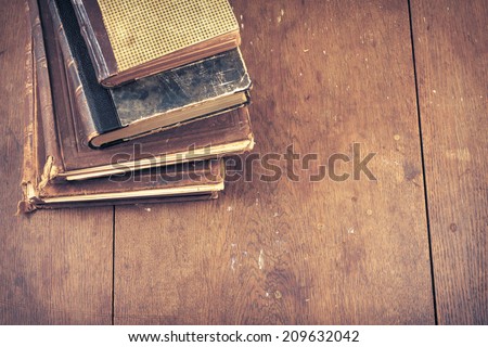 Old vintage books on wooden desk. Retro style filtered photo