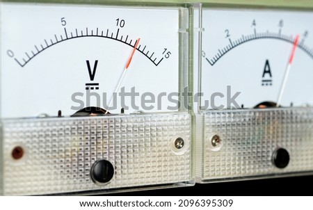 Arrow of the analog DC voltmeter shows the value of 12 volts.                  Royalty-Free Stock Photo #2096395309