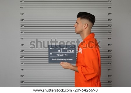 Prisoner with mugshot letter board at police department