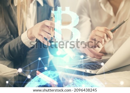 Double exposure of man and woman working together and crypto finance theme hologram. Blockchain business concept. Computer background.