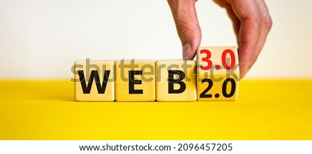 WEB 2 or 3 symbol. Businessman turns a wooden cube and changes words WEB 2.0 to WEB 3.0. Beautiful yellow table, white background, copy space. Business, technology and WEB 2.0 or 3.0 concept. Royalty-Free Stock Photo #2096457205