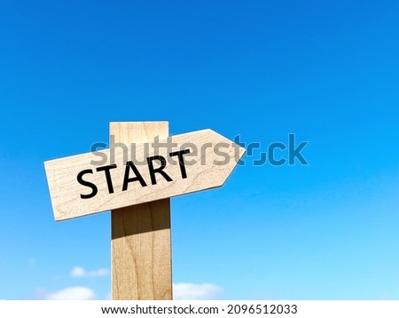 A road sign with a rising START character and blue sky