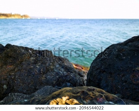 pebbles by the sea. Silky blue sea waves from long exposure. Stones on the Black Sea coast in cloudy weather against the background of the gray sea and sky in the Krasnodar Territory
