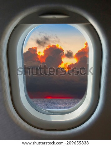 porthole and top view from the airplane on the blue sky and clouds