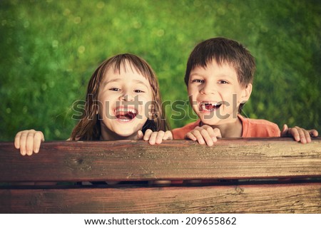 Outdoor portrait of smiling girl and boy who lost his milk teeth Royalty-Free Stock Photo #209655862