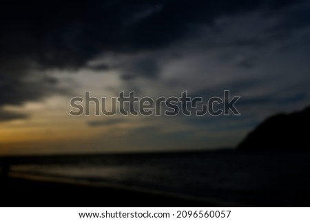 Image of a beach that is getting dark but the background is blurry.