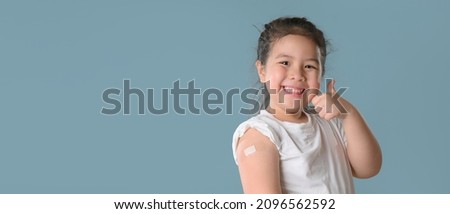 Coronavirus Vaccination Advertisement. Happy Vaccinated Little asian girl Showing Arm With Plaster Bandage After Covid-19 Vaccine Injection Posing Over Blue Background,  Royalty-Free Stock Photo #2096562592