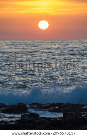 Sunset on the horizon and rocky shore
