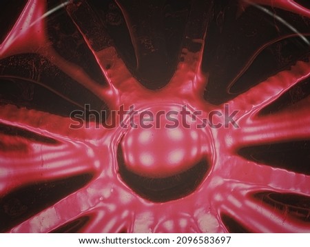 Overhead shot of a bottom of a glass filled with red wine on a black background