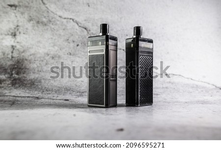 two vape electronic cigarettes on a gray background. High quality photo