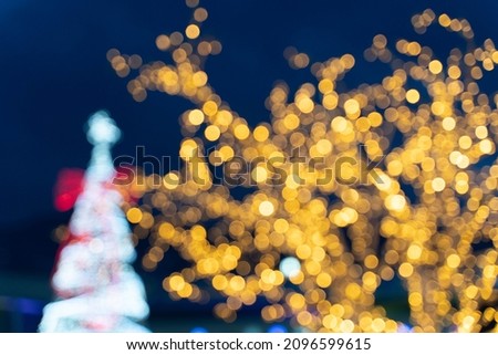 Blurred bokeh lights and Christmas tree behind.