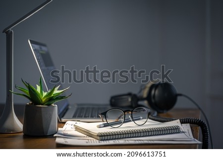Workplace with headphones and laptop in the evening, copy space.