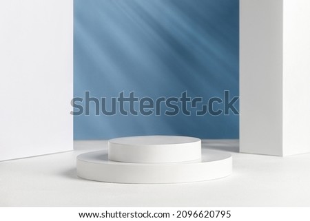Podiums for presentation and cosmetic. Natural beauty pedestal in sunlight. Shadow on blue wall. Photography