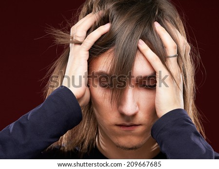 Portrait of a sick man having a migraine , isolated on dark background Royalty-Free Stock Photo #209667685