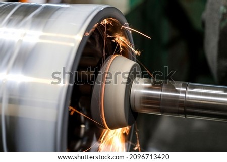 On the CNC machine, the inner cylindrical part is grinded from which sparks are spilled. Royalty-Free Stock Photo #2096713420