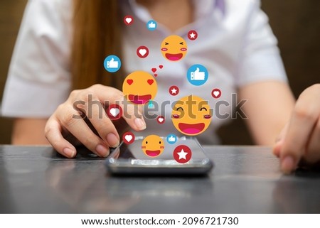 Young woman using a social media marketing concept on mobile phone with notification icons of like, message, comment and star above smartphone screen.