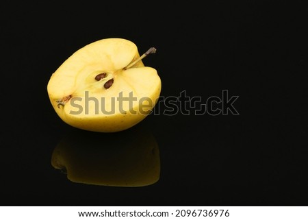 Yellow apple isolated on black mirror. High resolution photo. Full depth of field.