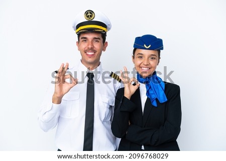 Airplane pilot and mixed race air hostess isolated on white background showing an ok sign with fingers