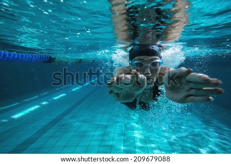 Athletic swimmer training on her own in the swimming pool at the leisure centre Royalty-Free Stock Photo #209679088