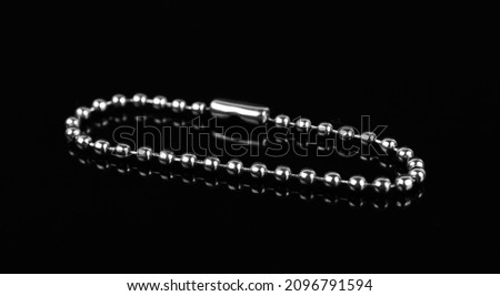 chain for a keychain, on a black background, isolated with reflection
