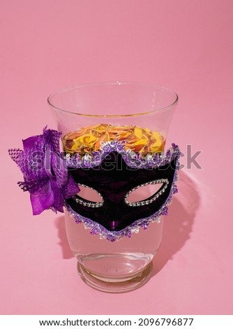 Woman face made of Colorful flower petals in big glass vase with  Carnevale 2022 and Carnival mask.