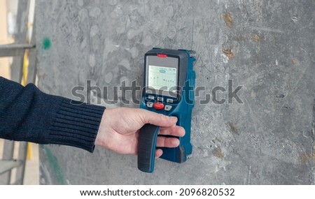 Inspection of the reliability of concrete structures. A device for ultrasonic examination of concrete, engineering background. Safe building concept.