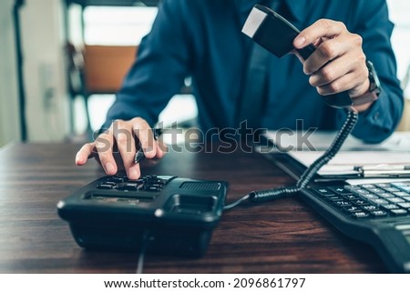 businessman dialing desk phone in the office. Telephone dialing ,contact and customer service. Royalty-Free Stock Photo #2096861797