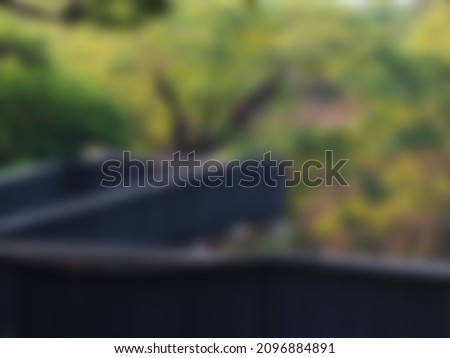 black gray bridge with blurry green trees used as a background