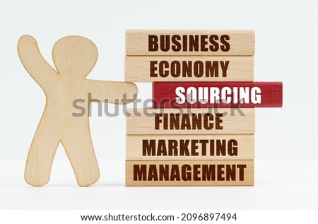 Business and economy concept. On a white background, a wooden man stands and pushes out of the wall a red wooden plate with the inscription - SOURCING