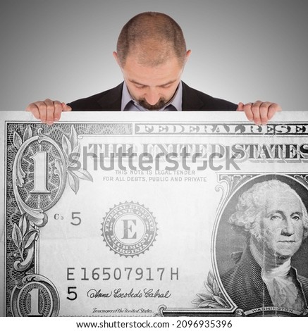 Business man holding a very large dollar bill