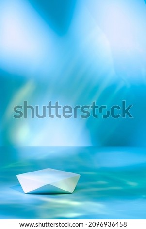Abstract surreal scene - empty stage with polygonal podium lying on pastel blue neon holographic colored background. Pedestal for cosmetic product packaging mockups display presentation