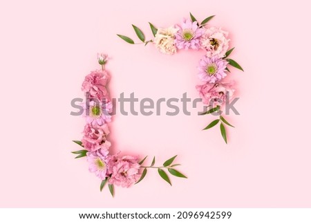 Flower border frame made of eustoma on a pink pastel background. Greeting card template with copyspace. Royalty-Free Stock Photo #2096942599