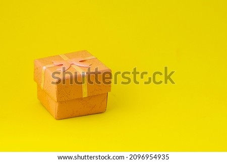 pink gift box on a yellow background with copyspace. High quality photo