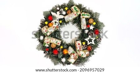 Christmas wreath decorating the front door for the holidays made of spruce, silver bows, stars and Christmas balls isolated on white background