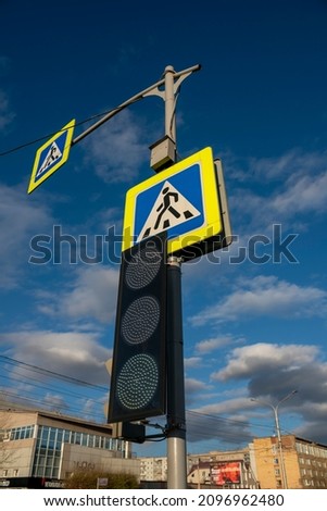 Pedestrian crossing road sign with traffic light. Traffic regulation in the city. City traffic safety.