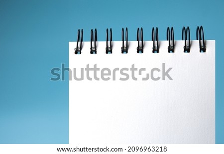 Blank notebook, spiral notebook 
on blue background. with copy space 