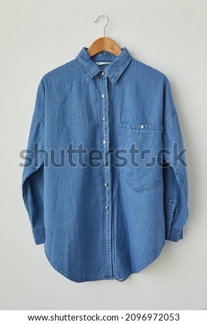 male stylish light blue jeans shirt isolated on a hanging background. blue denim long sleeve shirt