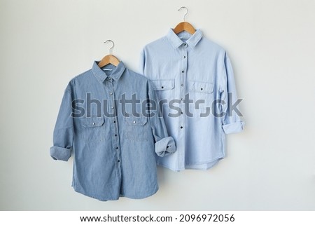 male stylish light blue jeans shirt isolated on a hanging background. Dark and light color long sleeve shirt