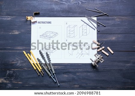 Furniture assembling instructions and tools on color wooden background Royalty-Free Stock Photo #2096988781