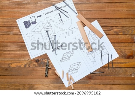 Furniture assembling plan, instructions and tools on wooden background Royalty-Free Stock Photo #2096995102