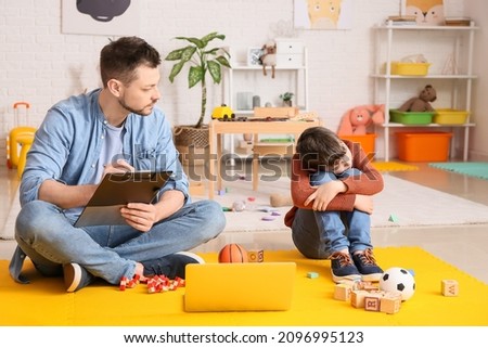 Male psychologist working with little boy in office. Autism concept Royalty-Free Stock Photo #2096995123