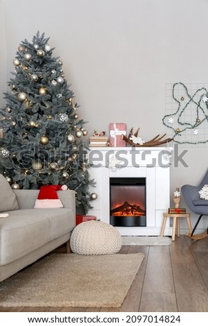 Beautiful decorated Christmas tree near fireplace in living room