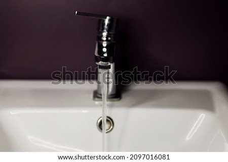 Open chrome faucet washbasin. working water tap