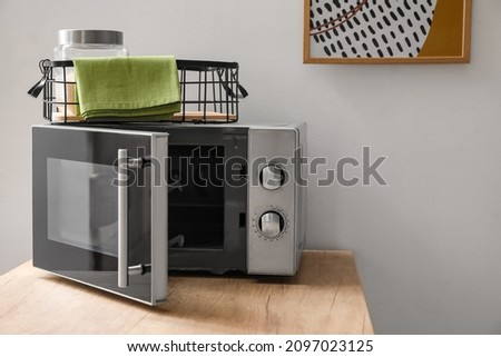 Microwave oven on wooden tabletop in modern kitchen
