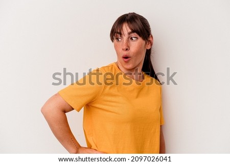 Young Argentinian woman isolated on white background looks aside smiling, cheerful and pleasant.