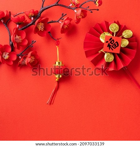 Top view of Chinese lunar new year background copy space design concept with red cherry blossom and festive decoration, the word inside picture means blessing.